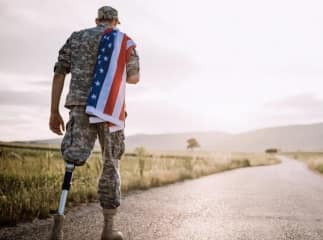 Soldier with a prosthetic leg draped in the American flag